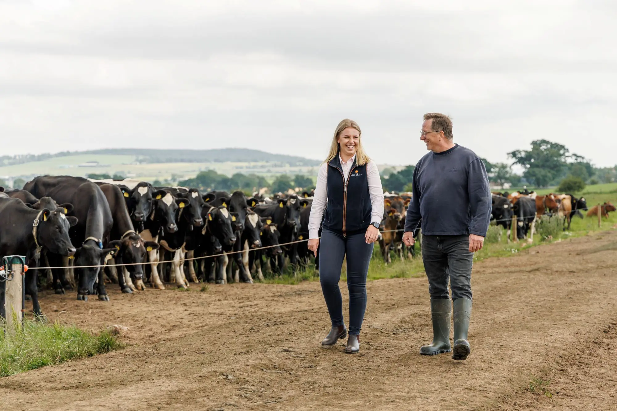 Farm consultant walking with client at dairy farm