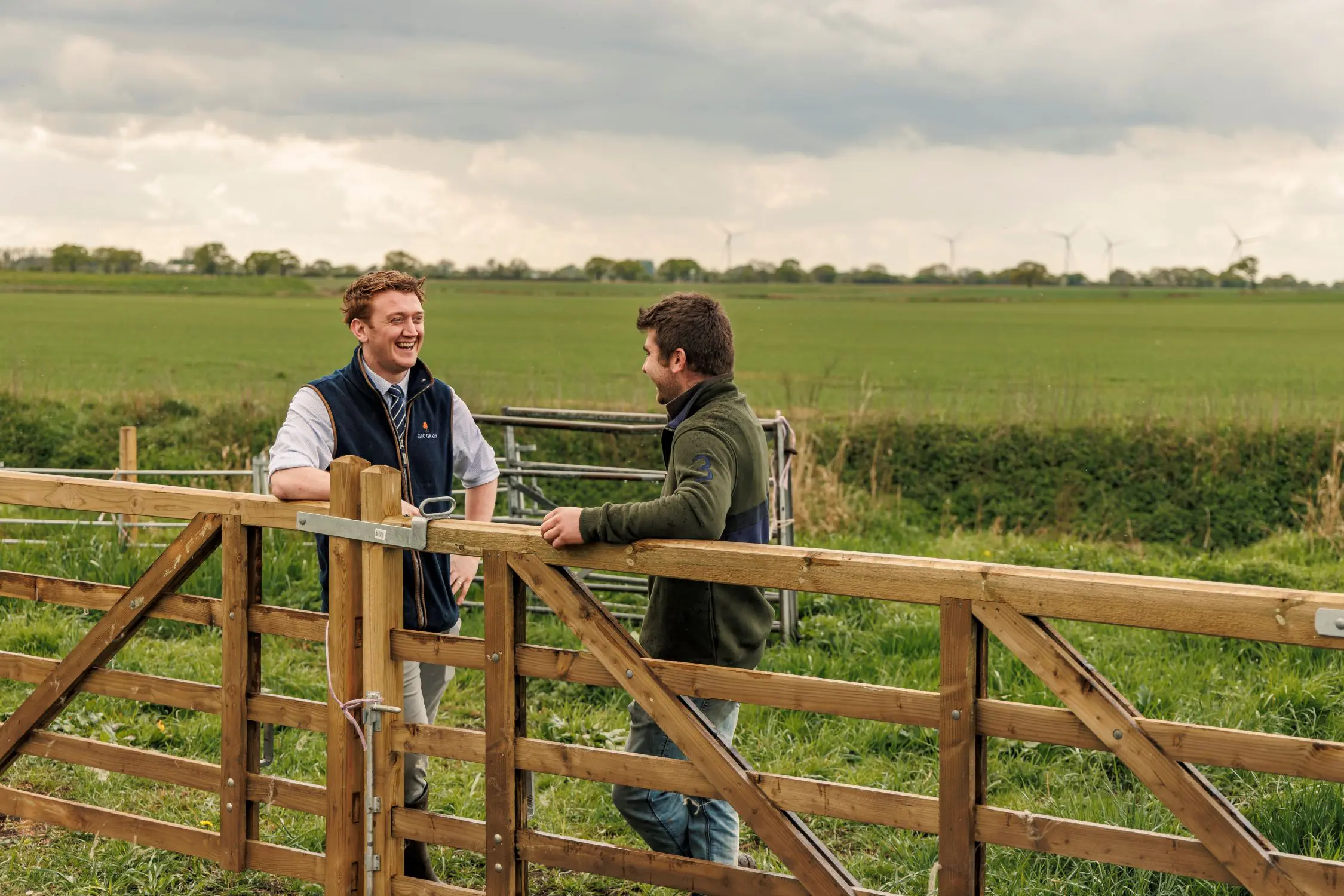 Farm consultant and client talking at farm gates