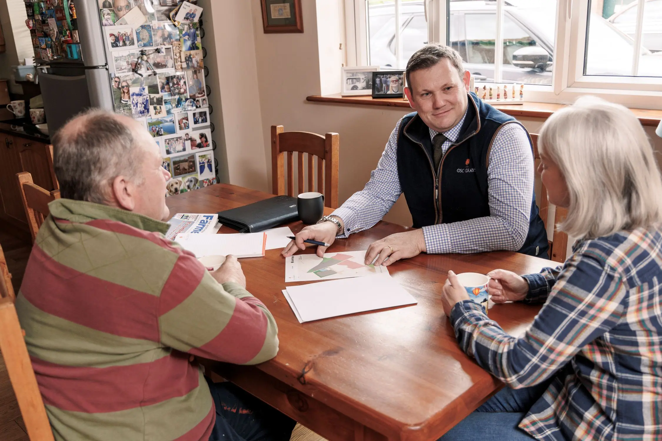 Farm consultant discussing with clients at kitchen table